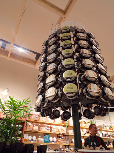 The gigantic body butter wheel, suspended high above the product testing island with an array of body butters around, like a palm tree of body butters.