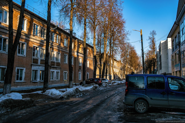 Улица, припаркованные машины и трехэтажные дома