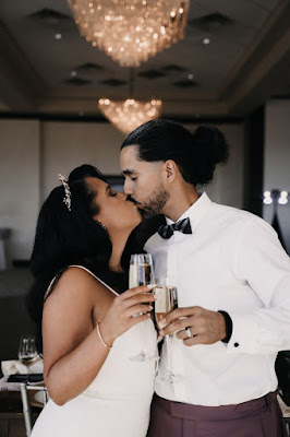 bride and groom kissing with champagne