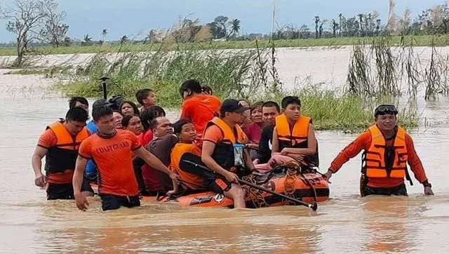 Rescuers pull a rubber boat as they assist residents who were trapped in their homes after floodwaters caused by Typhoon Rai inundated their village in Negros Occidental, central Philippines