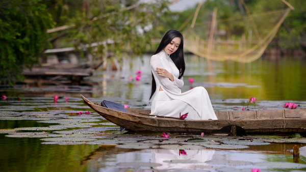 Thiếu nữ áo dài trắng ngồi trên thuyền