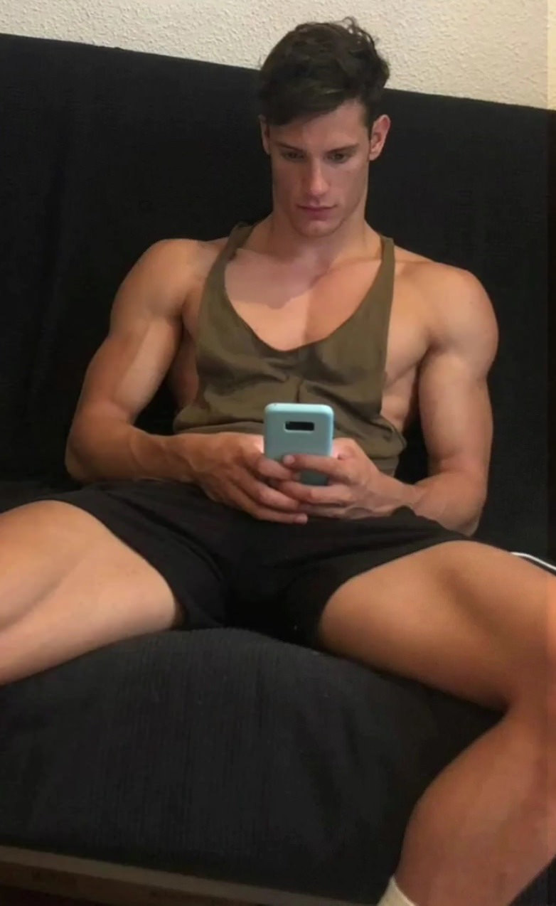 sexy-young-guy-wide-shoulders-biceps-cocky-teen-hunk-manspreading-texting