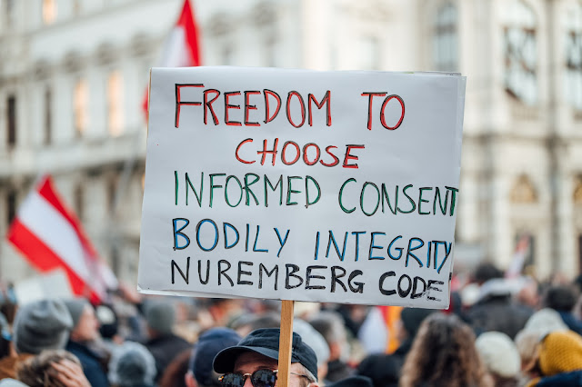 Sign with text "Freedom to choose. Informed consent. Bodily integrity. Nuremberg code". Protest against vax mandate in Austria