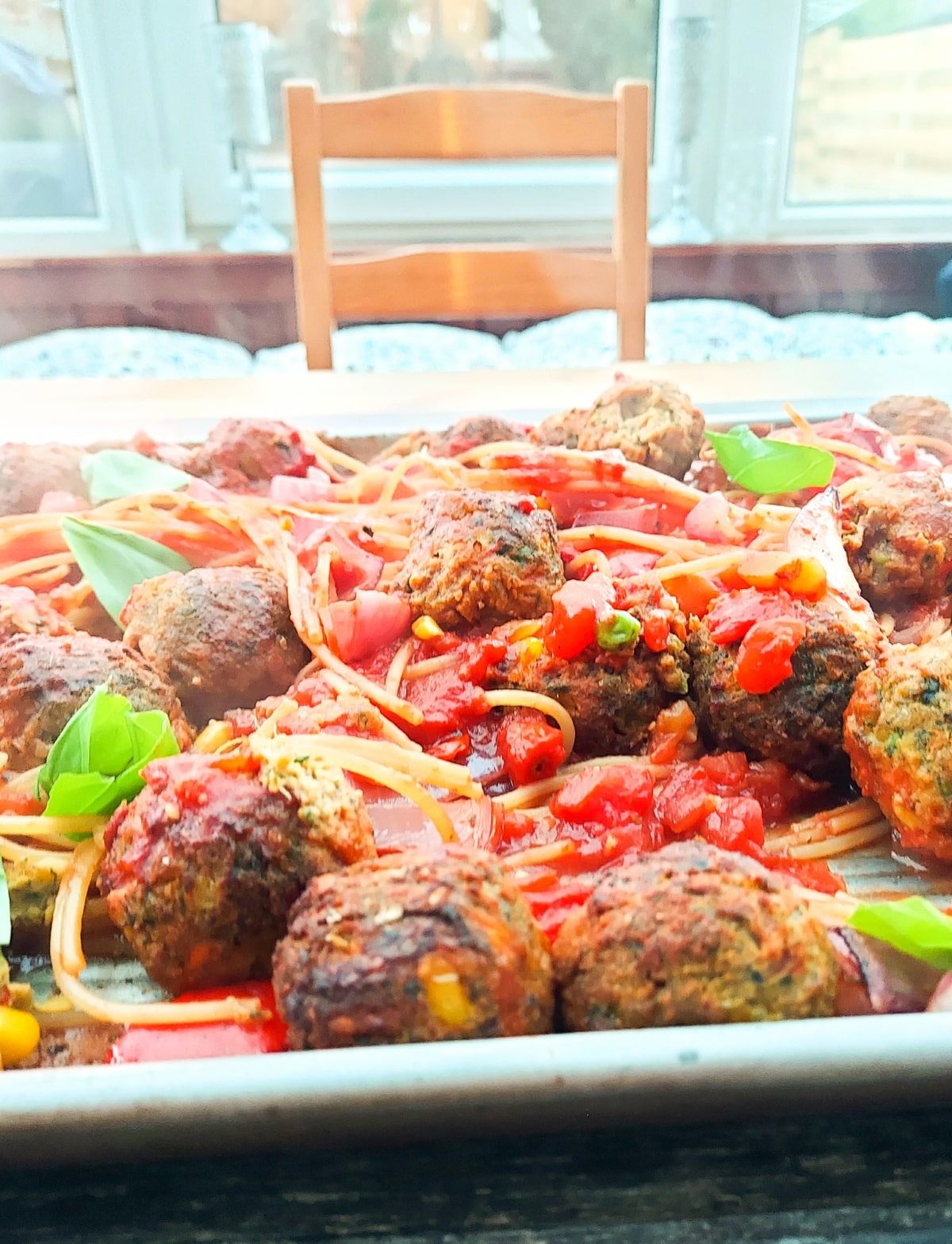 Vegan meatballs and spaghetti bake in a sheet pan