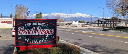 The snow-capped San Gabriel Mountains overlook the sign at Centro Basco