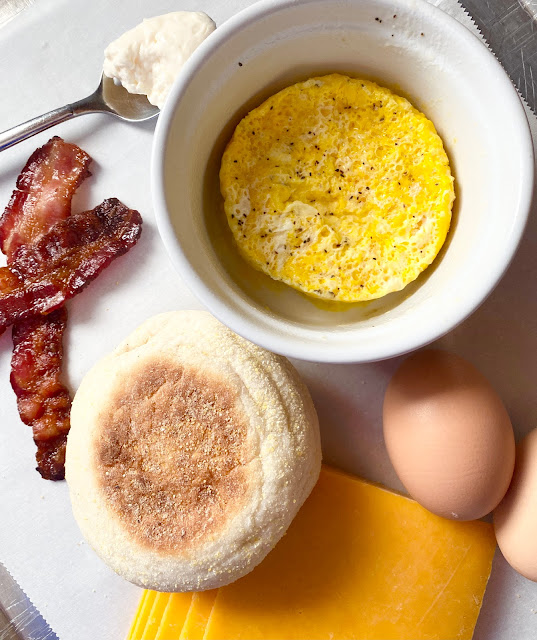 Ramekin of cooked egg, bacon, English muffin and cheese