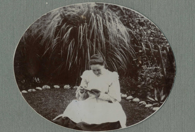 Lady sat reading in a garden
