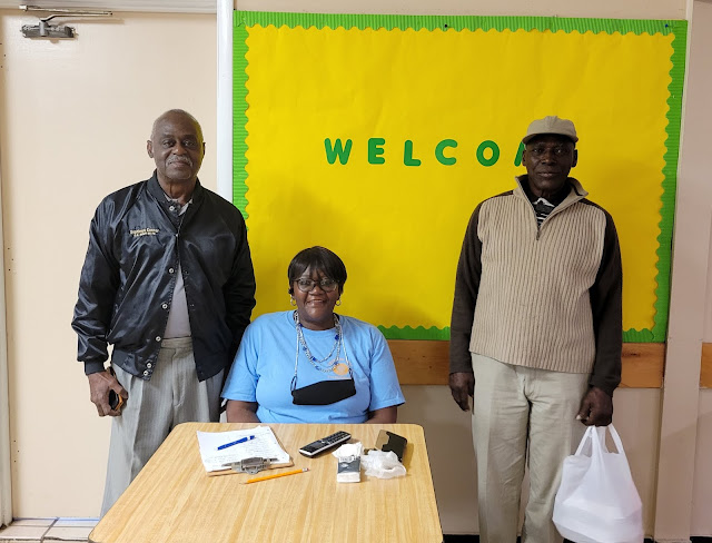 Wanda White from the American Legion Auxiliary Unit 194 is signing up Vietnam War veterans Septimus Connor and Albert Wright, Jr. for their free meals.