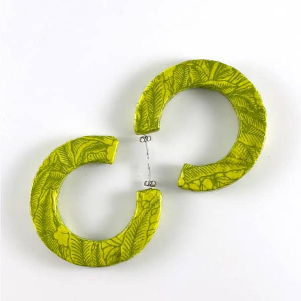 two lime green patterned paper earring hoops displayed on flat surface