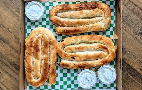 Beef, cheese, and spinach and cheese burek in a pizza box