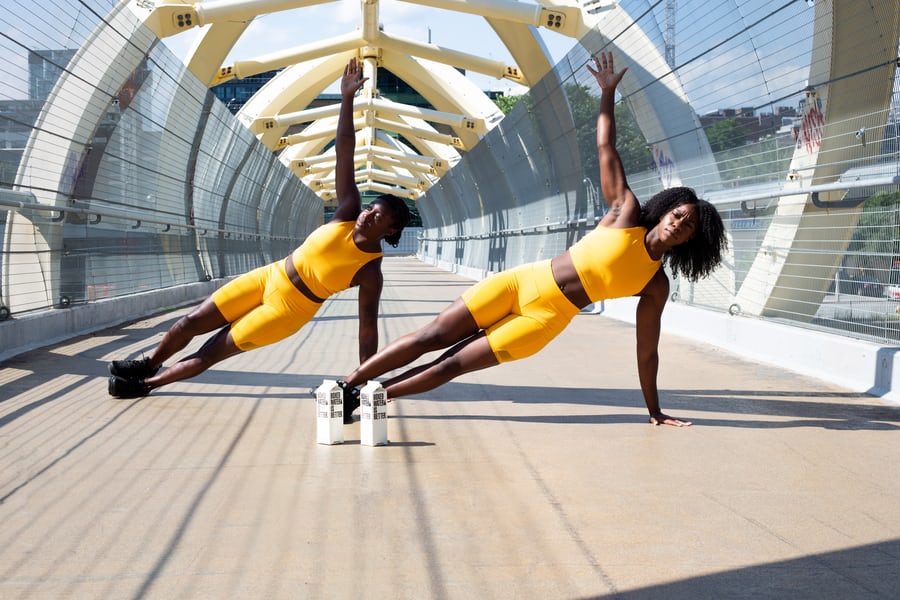 Two black women in yellow training dresses exercising to lose weight