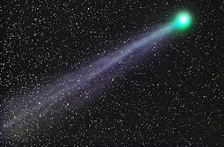 Lovejoy with its green head and a extended blue ion tail appears before a background of distant stars