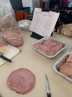 chicken breasts being prepped and placed in containers with ham sliced and put on top
