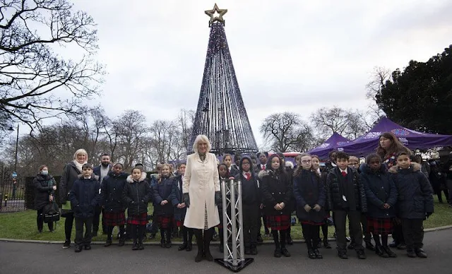 The Duchess of Cornwall wore a white tweed wool coat and beige polka-dot print silk midi dress