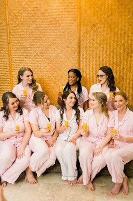 bride drinking mimosas with bridesmiads in pajamas