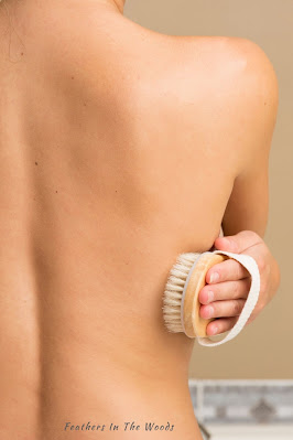A woman's bare back using a dry brush
