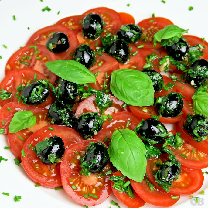 Recept: tomatensalade met kruidige gemarineerde olijven