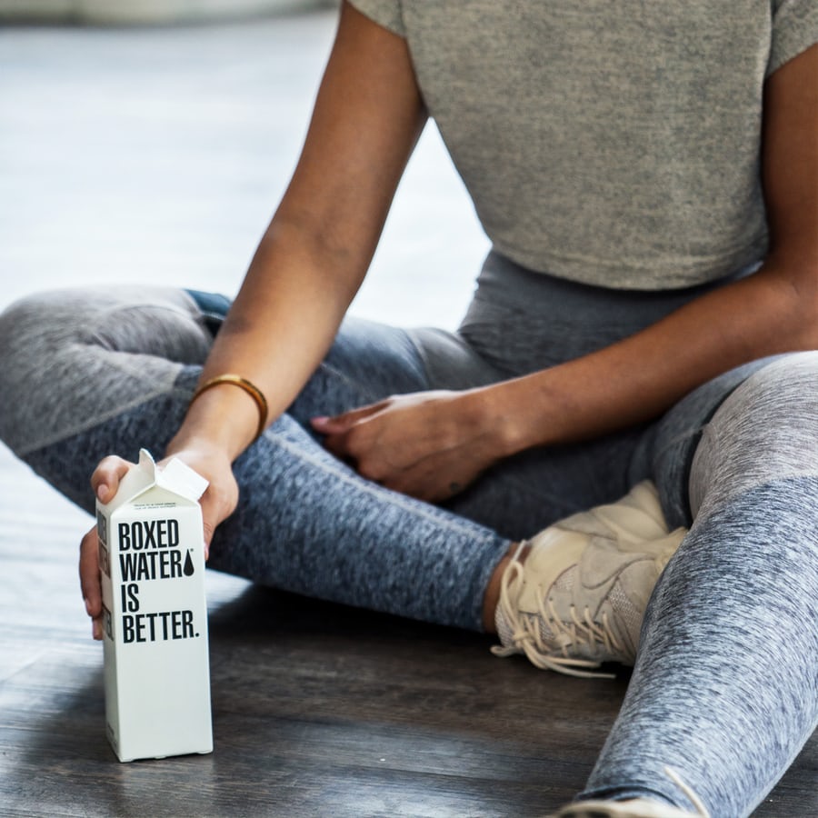 A woman in grey training gear relaxing after working out to lose weight