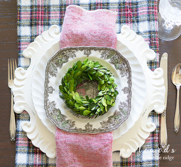 small boxwood wreath on place setting as Christmas table decorations