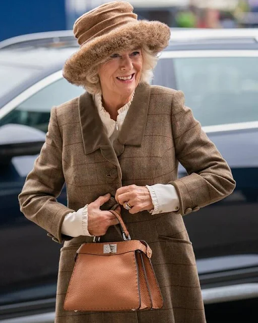 The Duchess wore a waist and a suede collar tweed coat by Roy Allen. She carried a small tan-coloured handbag