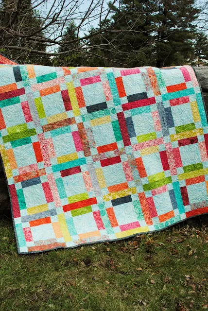 colorful quilt made using strips and squares