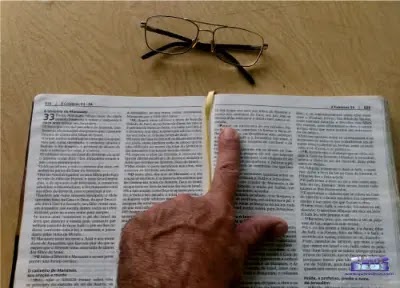 Dedo indicando um texto da Bíblia