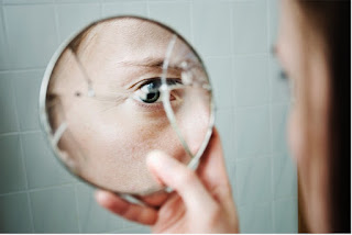 Eye looking into a broken mirror