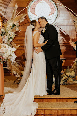 bride and groom kissing at altar