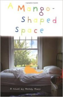 Front cover of Wendy Mass's book A Mango-Shaped Space. The title is in multi-colored letters and the image below is of an orange outline of a cat sitting on a bed in front of a window.
