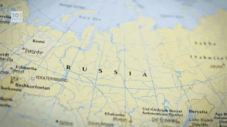 To fingers pointing at a map of Russia.