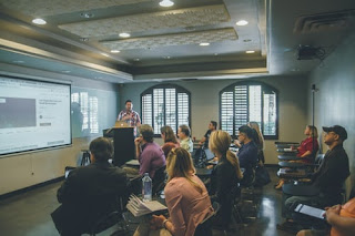 Seminar room, a man standind while other are sitting image