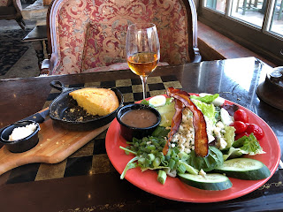 salad, glass of wine, and skillet cornbread