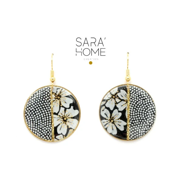 pair of circular black, white, and gold print dangle earrings
