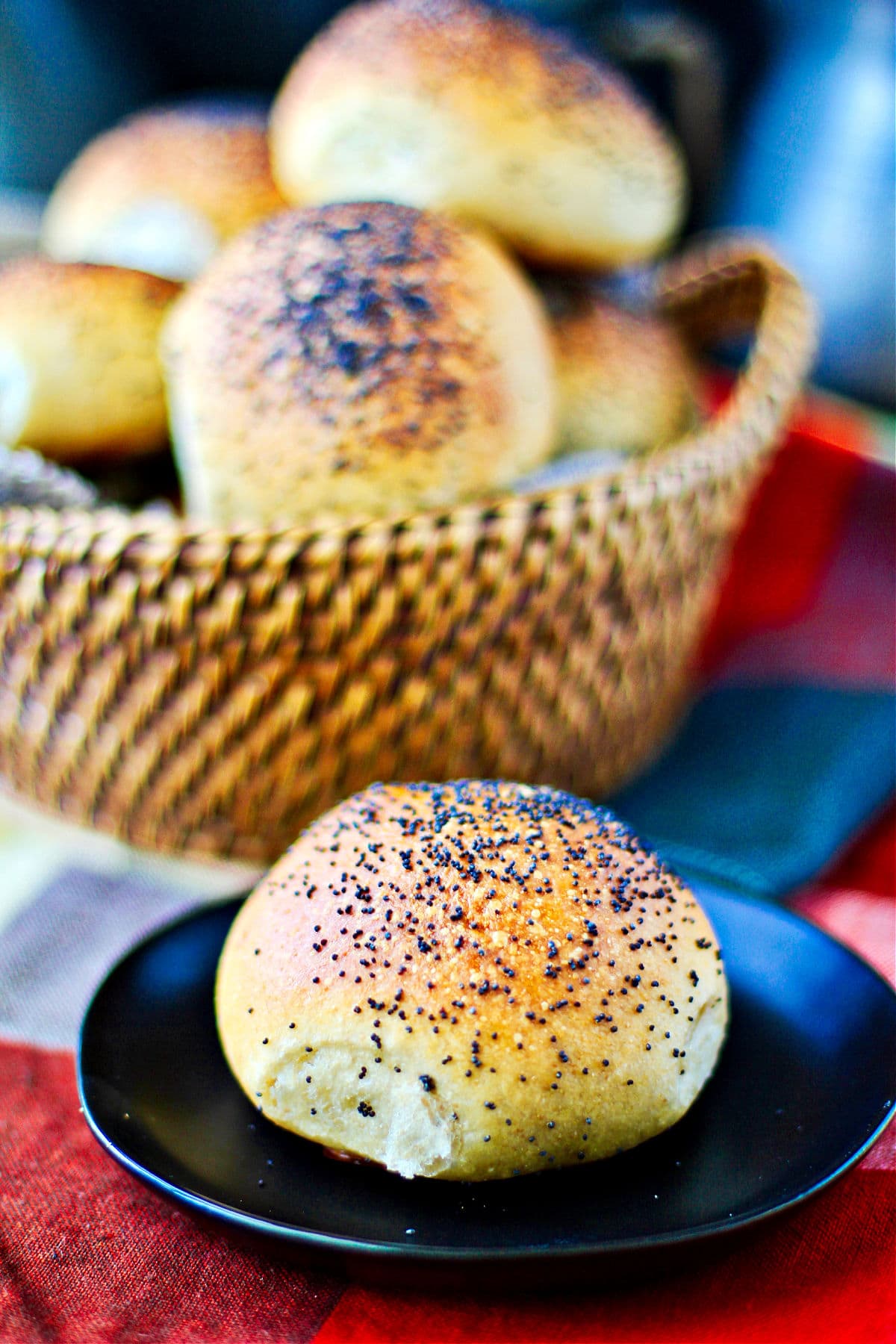 Dinner rolls in a basket with a plated roll in front.