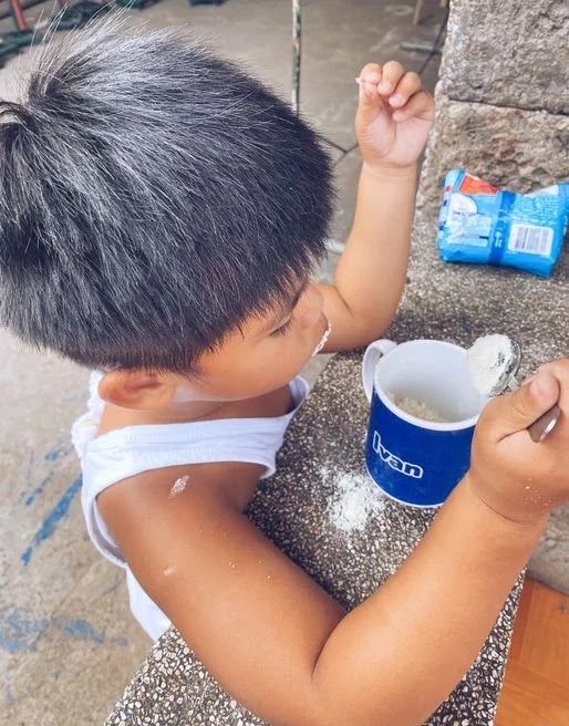 Little boy eating Bear Brand powdered milk