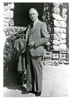 Photo of Rudolph Weaver holding a coat and hat