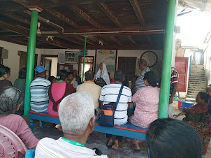 Tourists listening to local Minicoy lady villager explaining Minicoy Village community living.