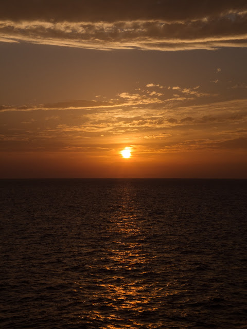 Sun casting a yellow/orange reflection across the Mediterranean Sea.