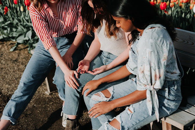 people sitting together on a bench outdoors