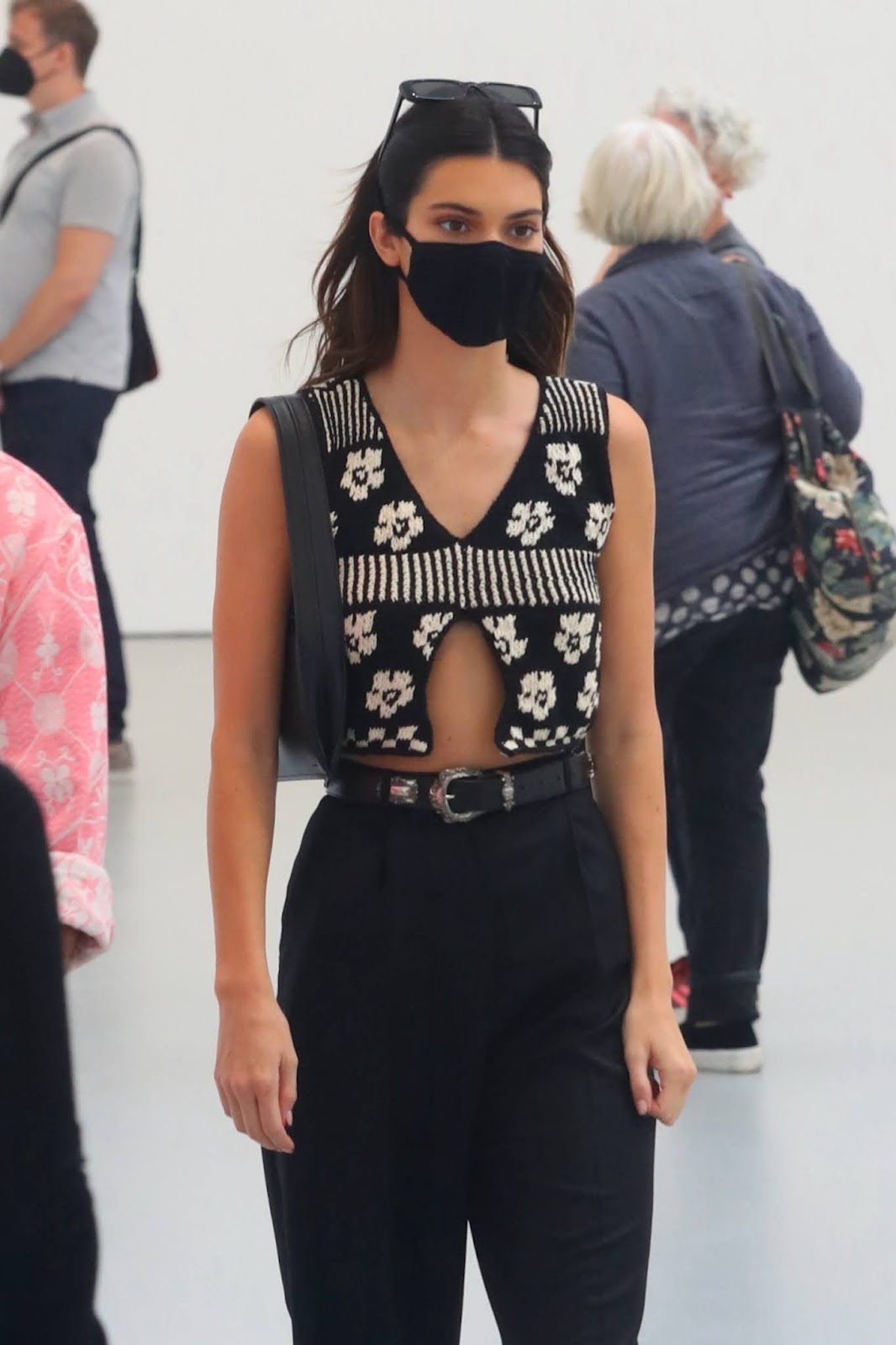 Kendall Jenner in a cropped top and pleated black trousers while visiting art galleries in New York City