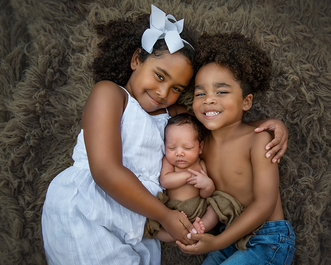 Newborn photo with two older siblings