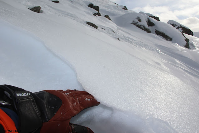 Una sottile lamella di ghiaccio alla superficie della neve, e sotto di essa cristalli a debole coesione sfaccettati.  Questo è lo strato debole importante per la neve fresca in arrivo. Alpi del Tux (Foto: 28.12.2021)