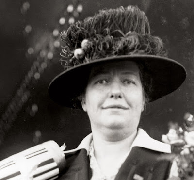 black & white photo of white woman with broad-brimmed hat with feathers