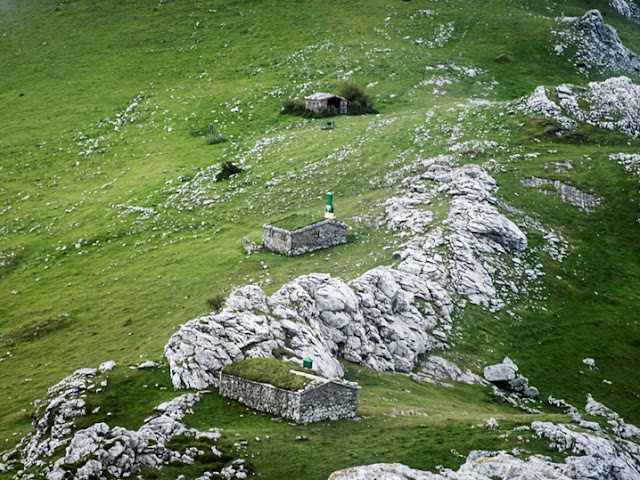 3 cabañas de piedra en urkiola entre rocas y verdes pastos