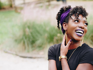 A woman holding her neck while smiling | Neck adjustment Ann Arbor