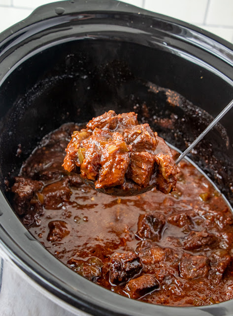 scoop of beef in a slow cooker.