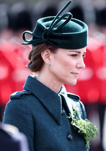 The Duchess wore a new Emilia green coat by Laura Green London. Cartier Shamrock Brooch and diamond and emerald earrings