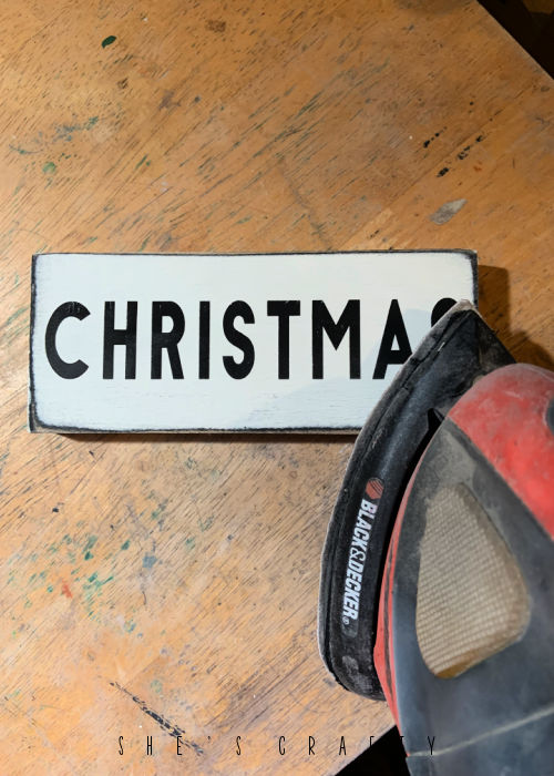 Distress wooden sign with hand sander.