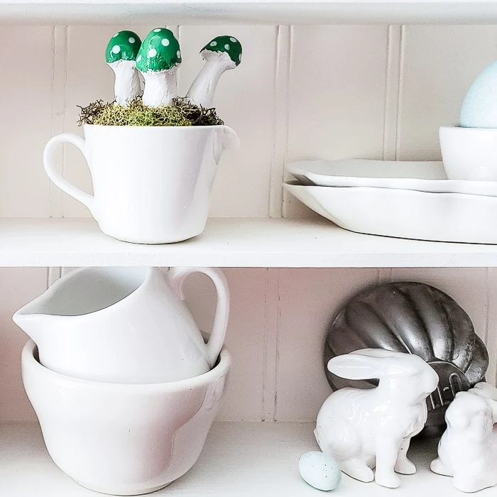 DIY clay mushrooms displayed with small ironstone pieces in cubby