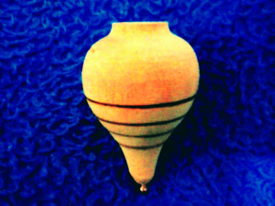 A foto mostra o pião de madeira o brinquedo de antigamente, criativo e fácil de bricar.
